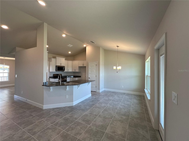 kitchen with a breakfast bar, a notable chandelier, lofted ceiling, white cabinetry, and decorative light fixtures