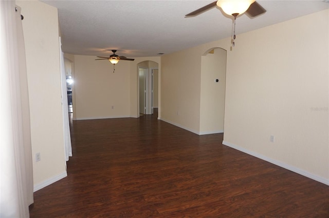 empty room with a textured ceiling, dark hardwood / wood-style flooring, and ceiling fan