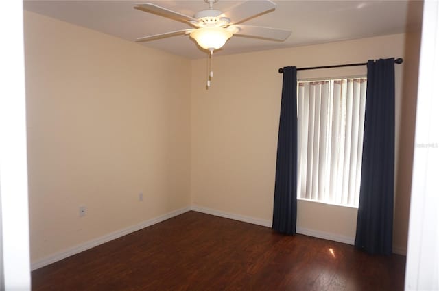 spare room with dark hardwood / wood-style flooring and ceiling fan