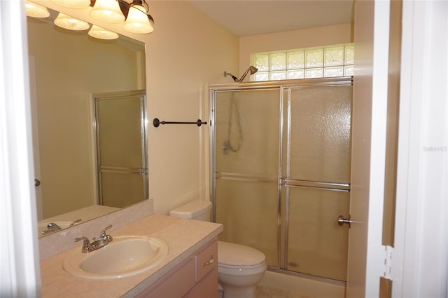 bathroom with walk in shower, vanity, tile patterned flooring, and toilet