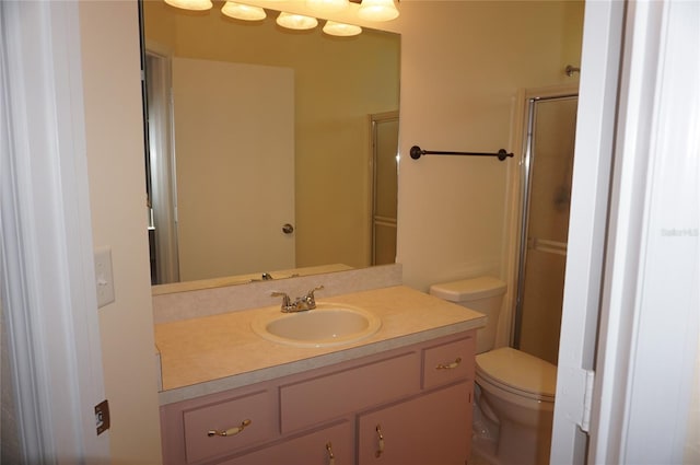 bathroom with vanity, toilet, and an enclosed shower