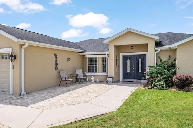 doorway to property with a garage and a yard