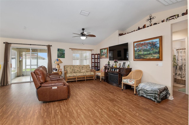 living room featuring hardwood / wood-style flooring, ceiling fan, and vaulted ceiling