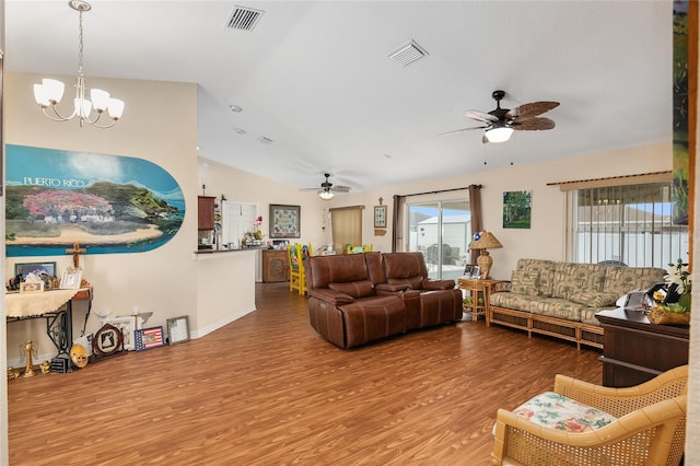 living room with hardwood / wood-style flooring, lofted ceiling, and ceiling fan with notable chandelier