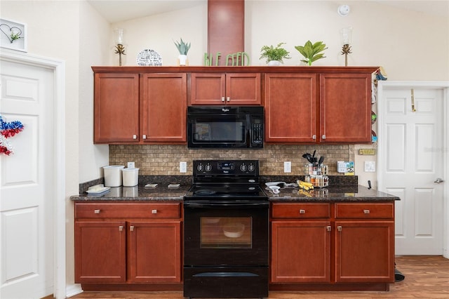 kitchen with tasteful backsplash, hardwood / wood-style floors, dark stone counters, and black appliances