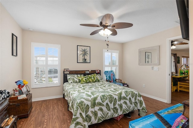 bedroom featuring multiple windows, dark hardwood / wood-style flooring, and ceiling fan