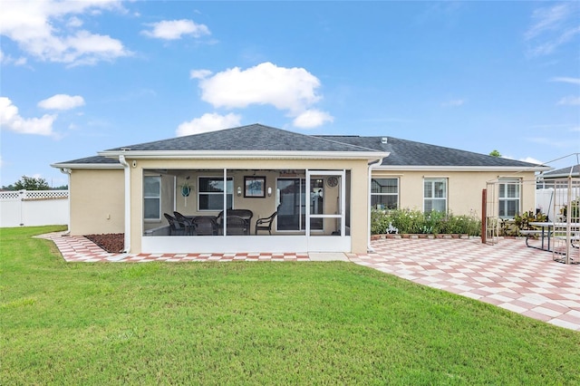 rear view of house featuring a patio, a yard, and a sunroom