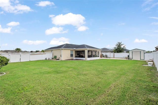 back of house featuring a lawn, a sunroom, and a storage unit