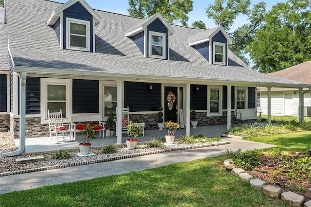 cape cod home with a front lawn and a porch