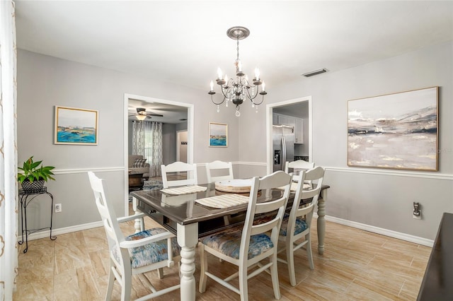 dining space with ceiling fan with notable chandelier