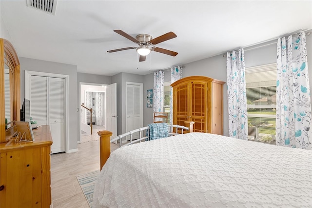 bedroom with ceiling fan and two closets