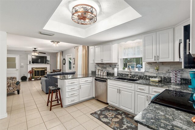 kitchen with white cabinets, dishwasher, kitchen peninsula, and sink