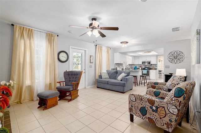 tiled living room featuring ceiling fan