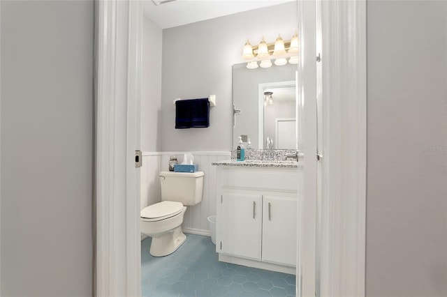 bathroom with tile patterned flooring, vanity, and toilet