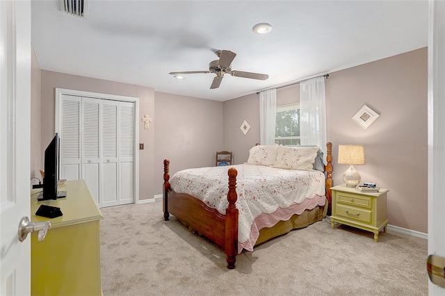 bedroom with a closet, ceiling fan, and light colored carpet