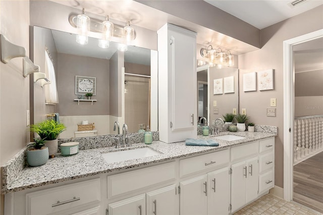 bathroom with hardwood / wood-style floors, a shower with door, and vanity