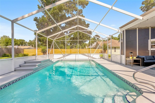 view of pool with glass enclosure and a patio area