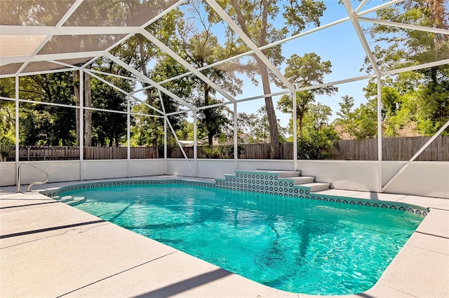 view of swimming pool with glass enclosure and a patio