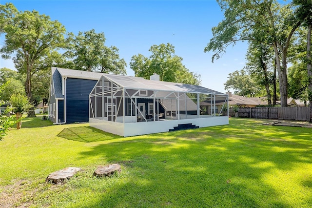 back of property featuring a yard and glass enclosure