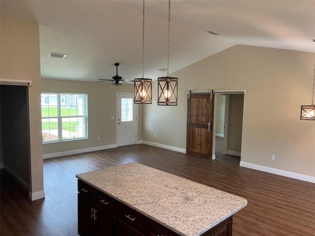 kitchen featuring a barn door, hanging light fixtures, dark hardwood / wood-style flooring, and ceiling fan