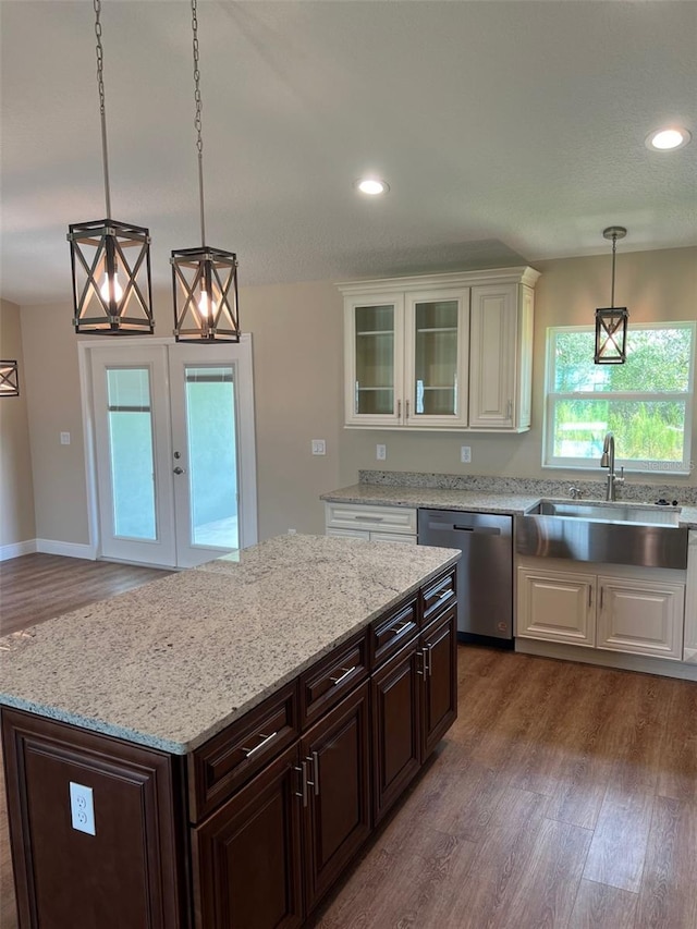 kitchen featuring dishwasher, dark brown cabinets, decorative light fixtures, dark hardwood / wood-style floors, and sink