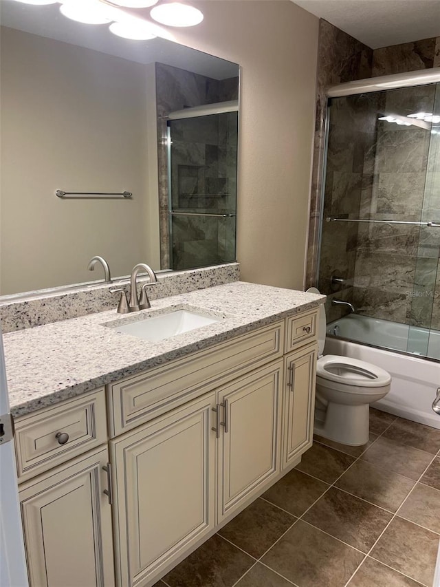 full bathroom featuring tile patterned floors, combined bath / shower with glass door, vanity, and toilet