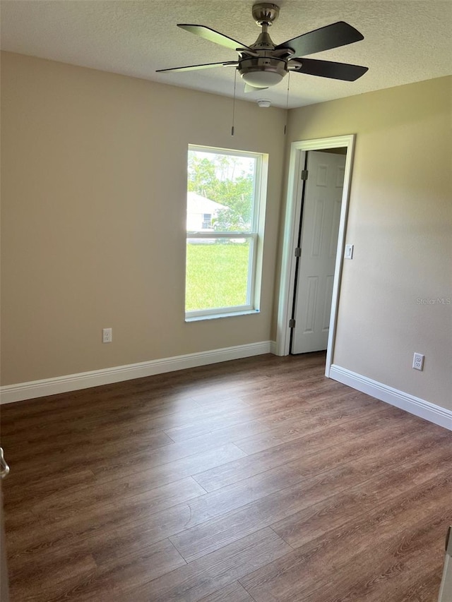 unfurnished bedroom featuring ceiling fan, hardwood / wood-style flooring, and a textured ceiling