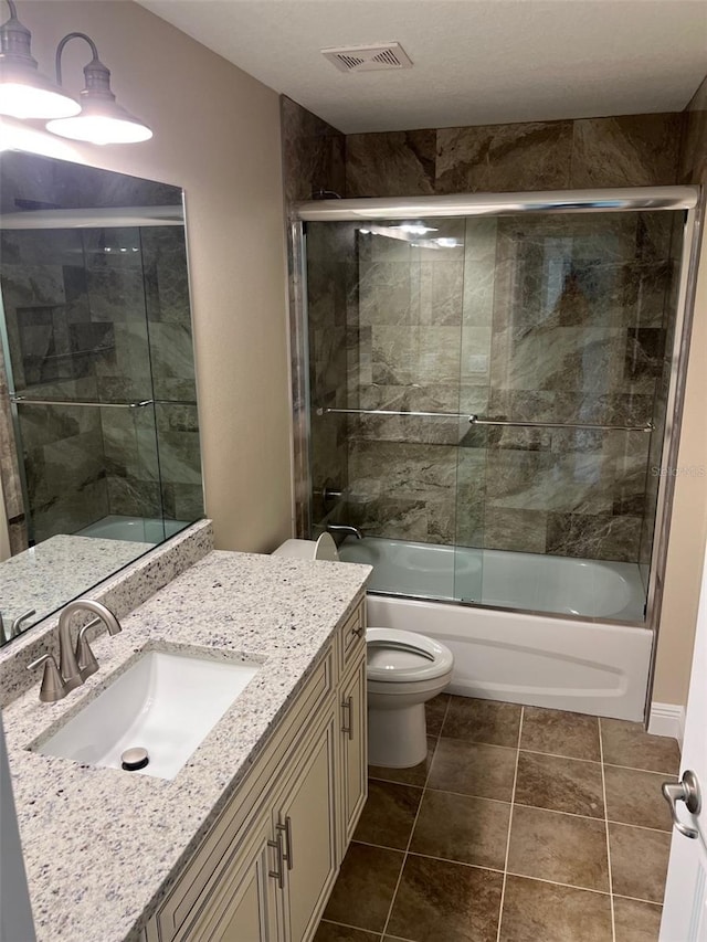 full bathroom featuring enclosed tub / shower combo, vanity, toilet, and tile patterned floors