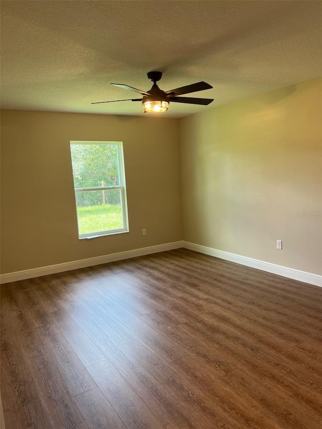 unfurnished room with a textured ceiling, dark hardwood / wood-style floors, and ceiling fan