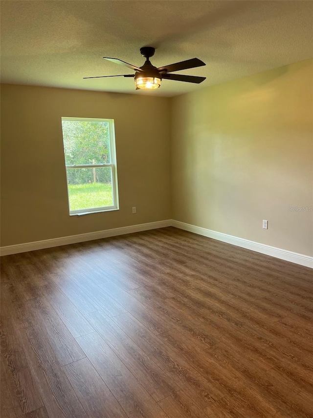 unfurnished room featuring ceiling fan, a textured ceiling, and dark wood-type flooring