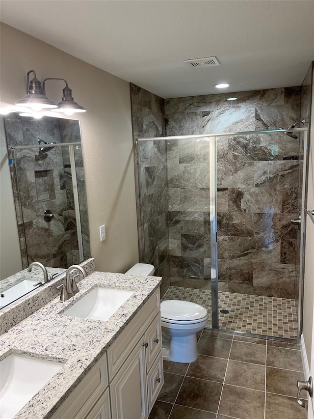 bathroom featuring vanity, toilet, tile patterned floors, and an enclosed shower