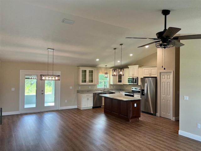 kitchen featuring a kitchen island, ceiling fan, stainless steel appliances, and plenty of natural light