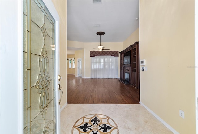 foyer entrance with light wood-type flooring and ceiling fan