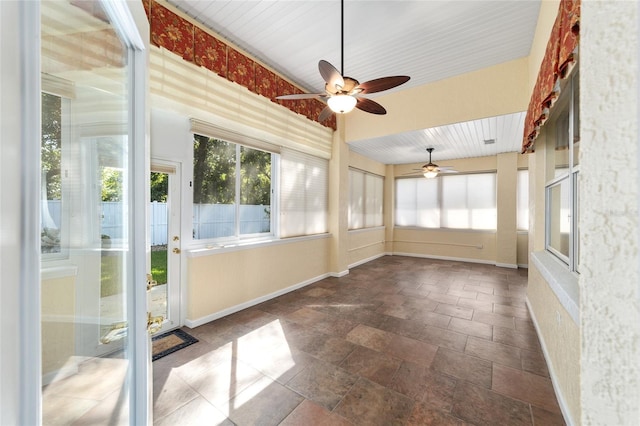 unfurnished sunroom with ceiling fan