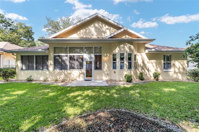 rear view of house featuring a sunroom and a yard