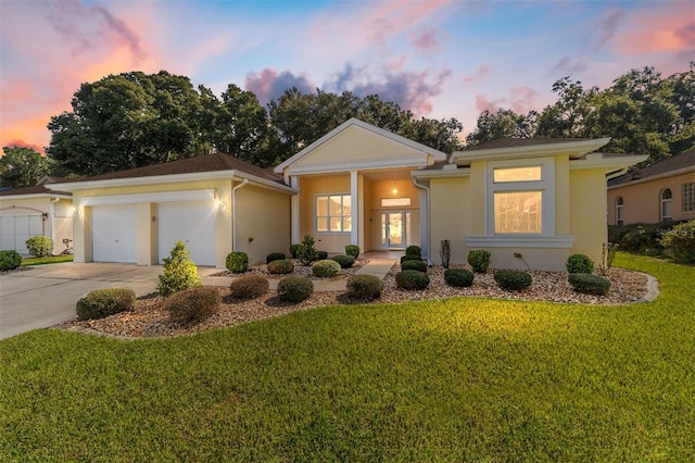 view of front of property with a yard and a garage