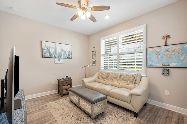 living room with wood-type flooring and ceiling fan