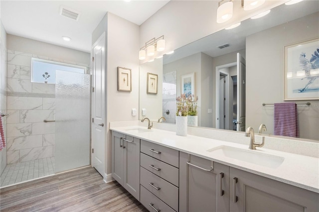 bathroom featuring a tile shower, vanity, and hardwood / wood-style flooring