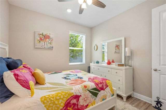 bedroom featuring light wood-type flooring, ceiling fan, and radiator