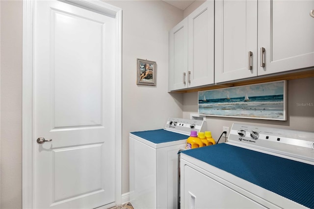 laundry area featuring washing machine and clothes dryer and cabinets