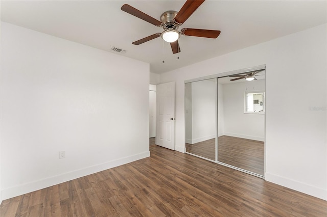 unfurnished bedroom featuring ceiling fan, a closet, and dark hardwood / wood-style flooring