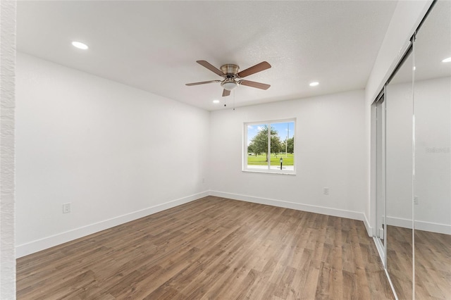 unfurnished bedroom featuring a textured ceiling, wood-type flooring, ceiling fan, and a closet