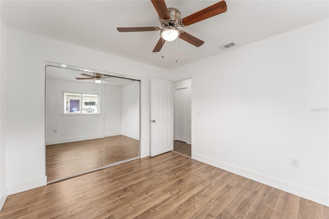 unfurnished bedroom with ceiling fan, light hardwood / wood-style flooring, and a closet