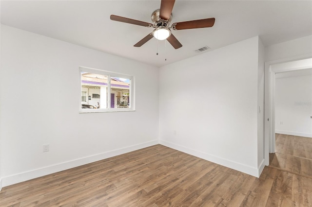 empty room with ceiling fan and hardwood / wood-style flooring