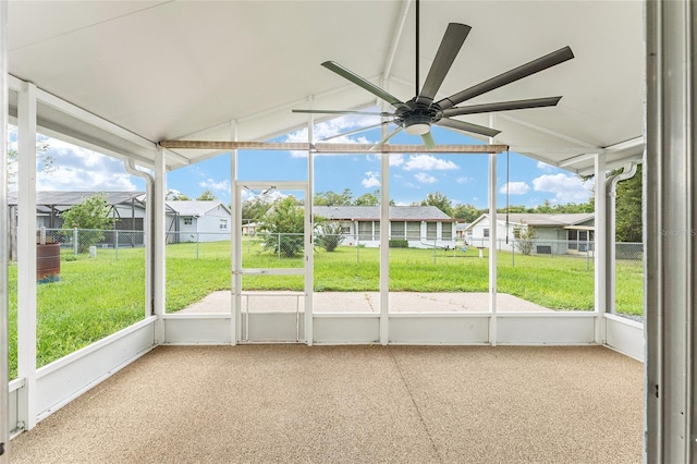 unfurnished sunroom with lofted ceiling, ceiling fan, and a wealth of natural light