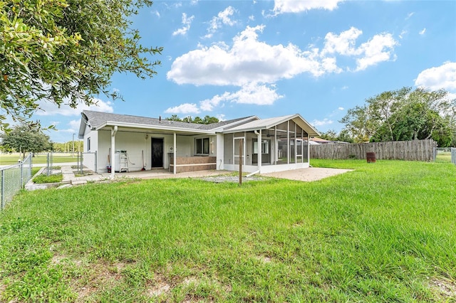 rear view of property with a patio, a yard, and a sunroom