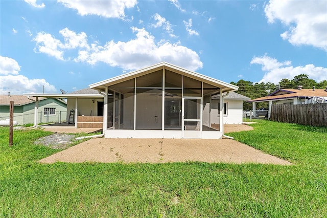 rear view of house featuring a sunroom and a lawn