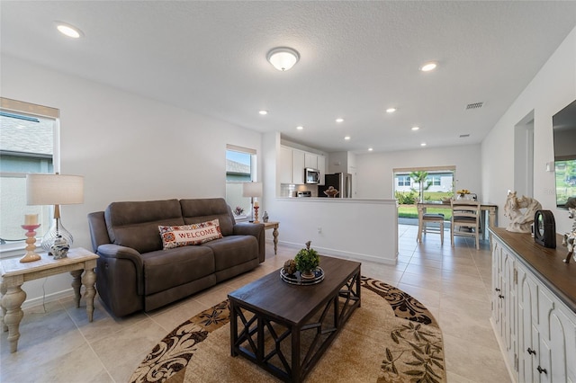 living room featuring light tile patterned floors and a textured ceiling