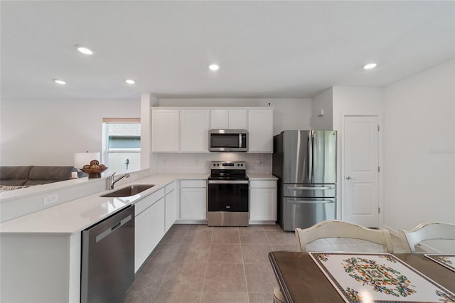 kitchen featuring white cabinets, sink, light tile patterned floors, appliances with stainless steel finishes, and backsplash