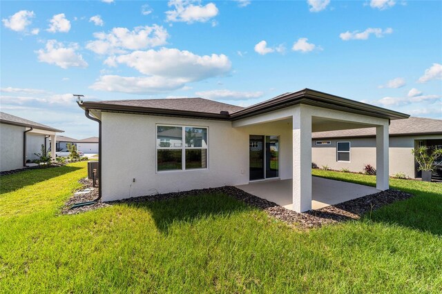 back of property featuring a lawn and a patio area